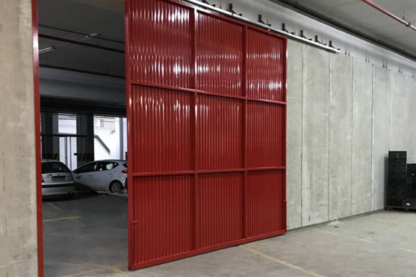 Puerta metálica corredera roja en almacén.
